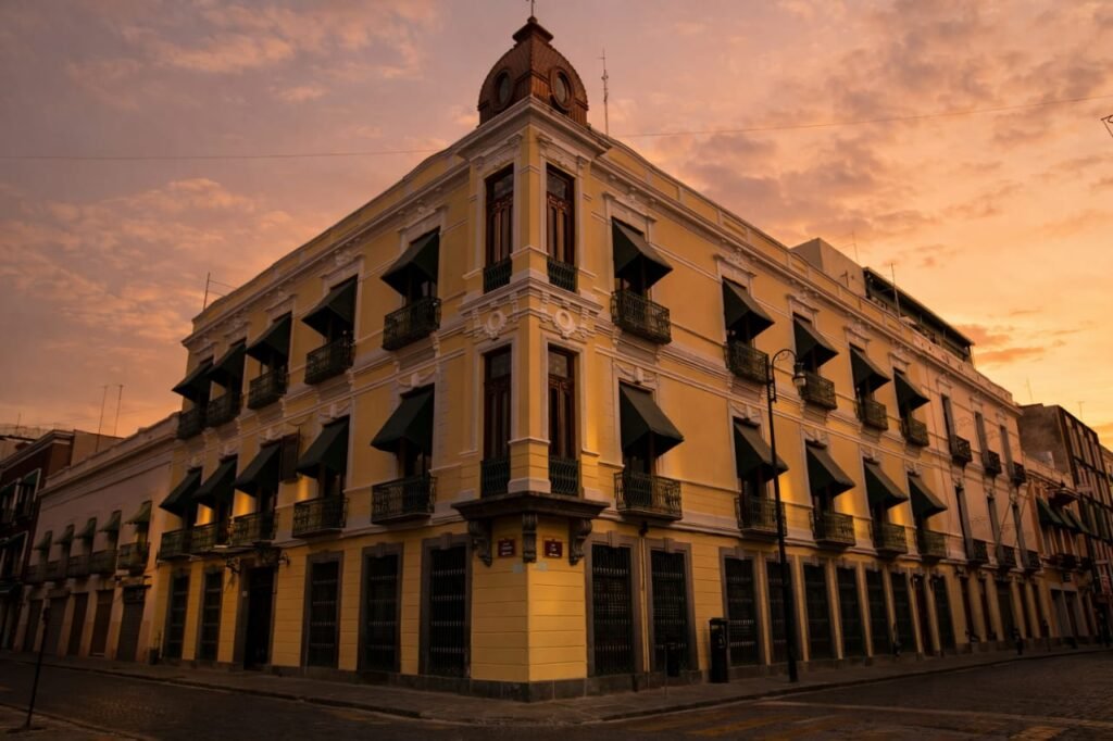 Fachada del Museo José Luis Bello y González en contraesquina con su arquitectura colonial, la calle está vacía, con iluminación cálida y muy tenue, se puede observar el cielo del atardecer.