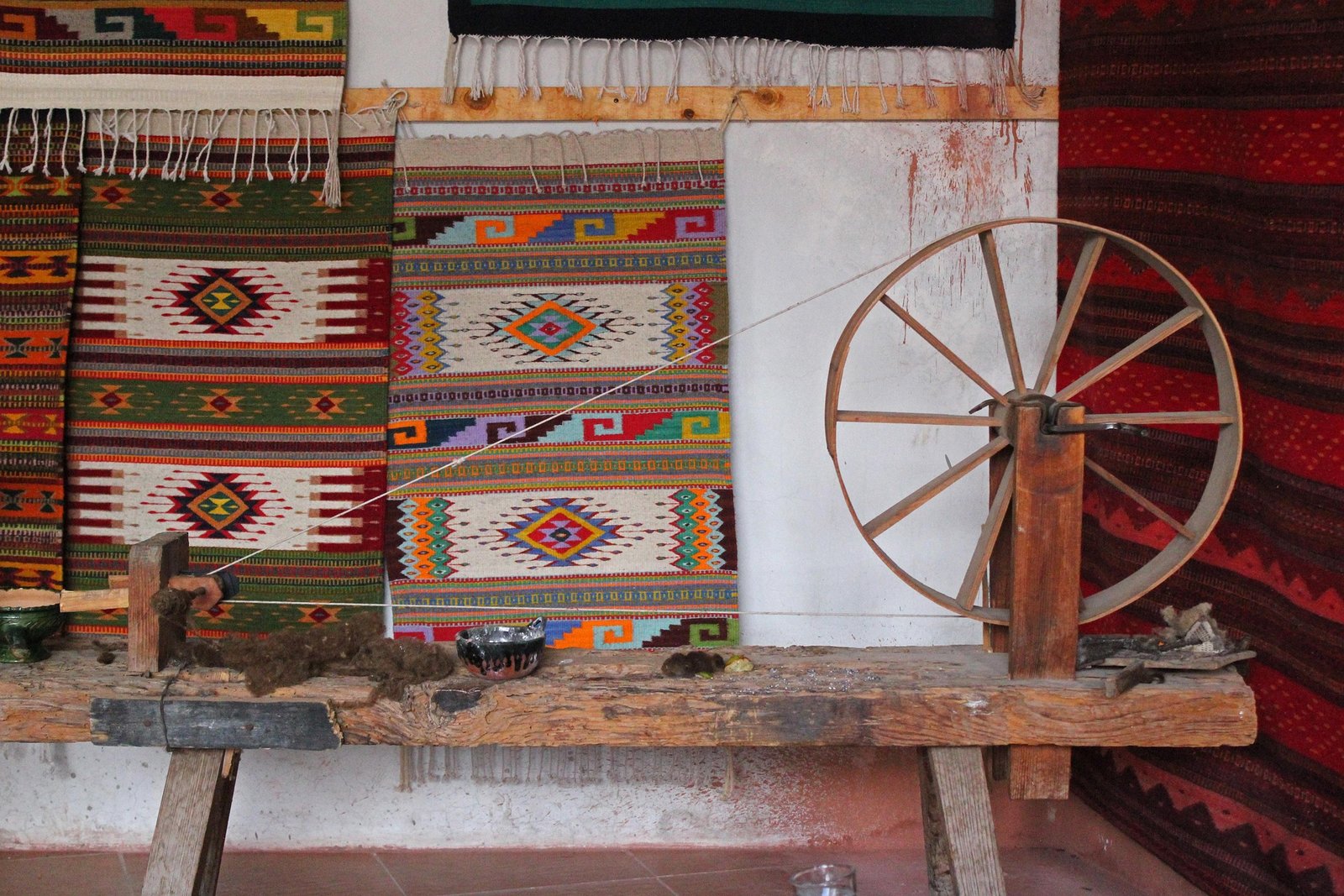 Telar artesanal de madera con textiles oaxaqueños y diseños tradicionales mexicanos