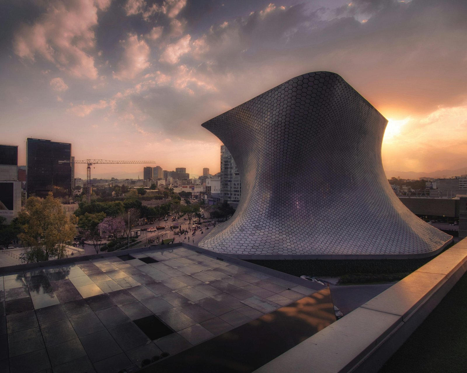 Stunning sunset view of the iconic Soumaya Museum in Mexico City, showcasing its modern architecture and cityscape.