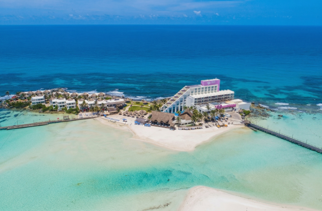 Vista aérea del hotel Mia Reef en el islote privado de Isla Mujeres, Practica el snorkel en Riviera Maya rodeado por aguas cristalinas. parte de un turismo de aventura acompañada de biodiversidad marina.