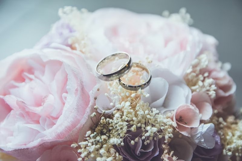anillos de matrimonio sobre un ramo de flores en tonos rosa pastel y blanco para una boda en Cancún