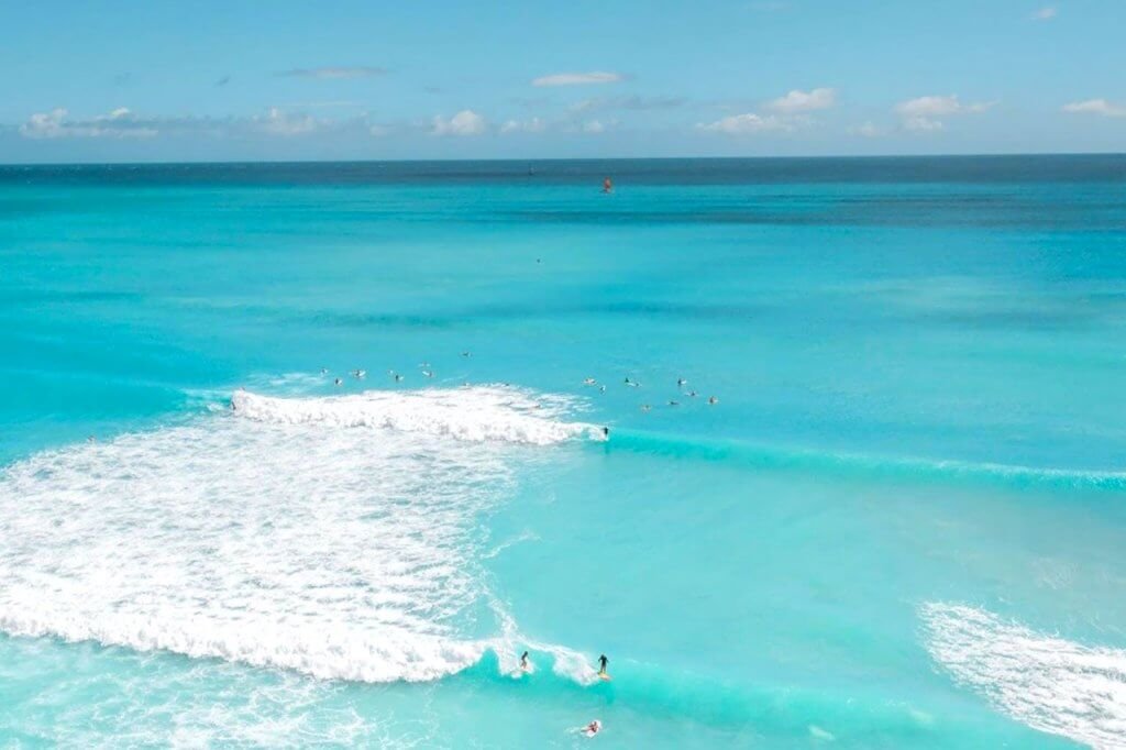 Surf en Playa Marlin, oleaje y aguas cristalinas color turquesa de fondo