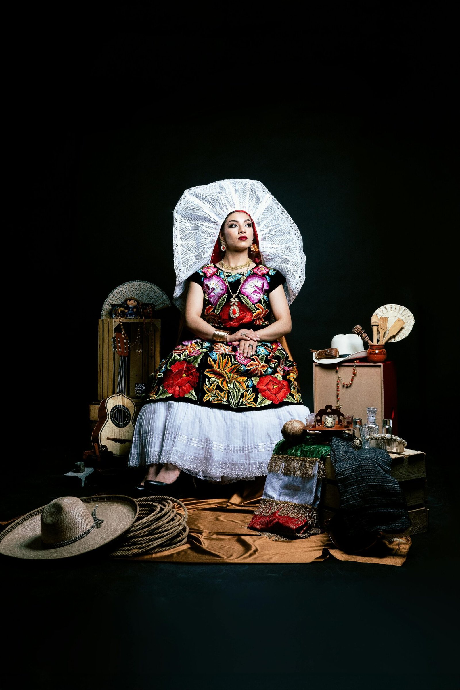 Mujer vestida con traje típico de Tehuana de Oaxaca, con huipil bordado, falda de flores y resplandor de encaje blanco