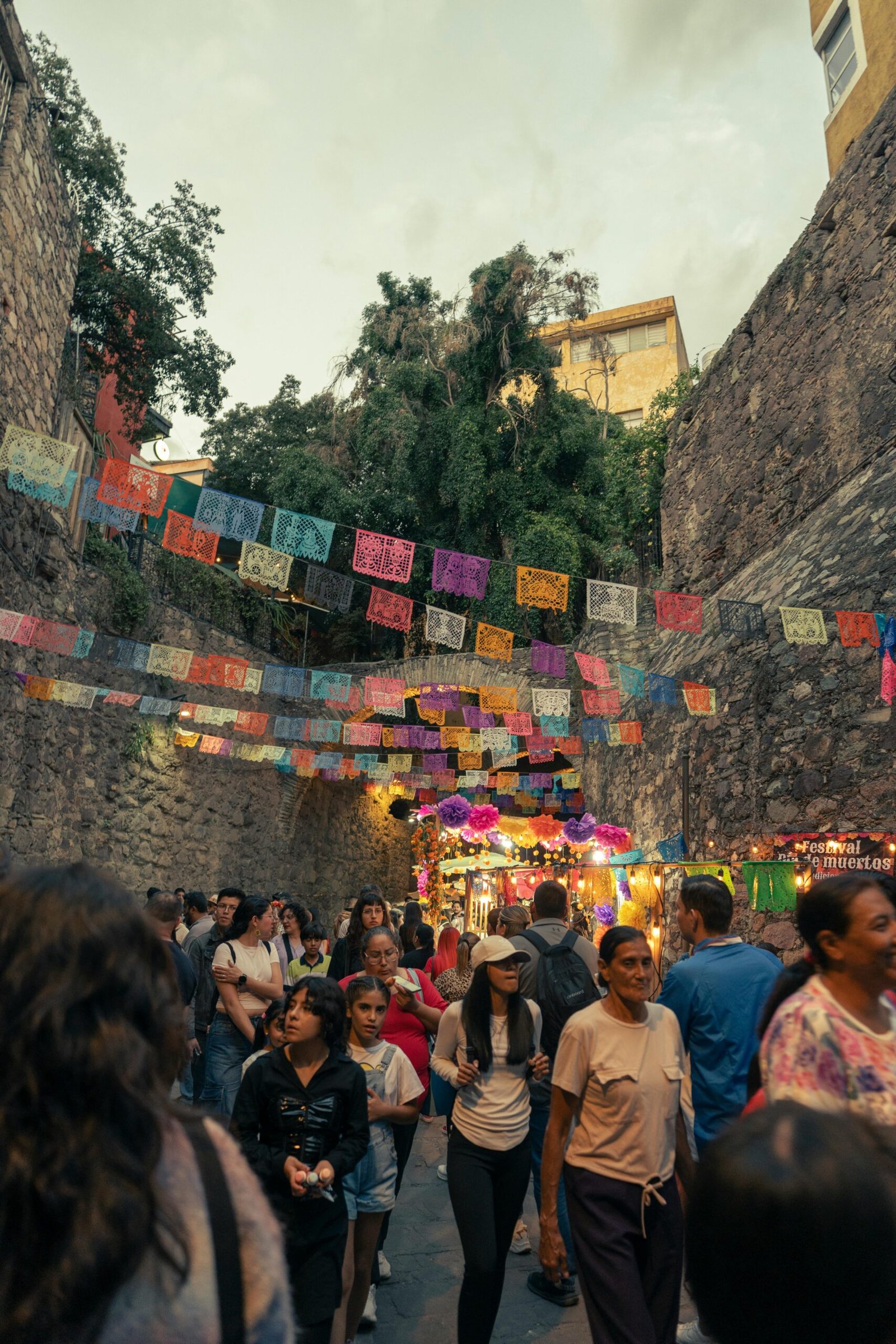 Fotografía de la entrada de uno de los túneles de la ciudad de Guanajuato, con decoración tradicional, gente y locales ambulantes.