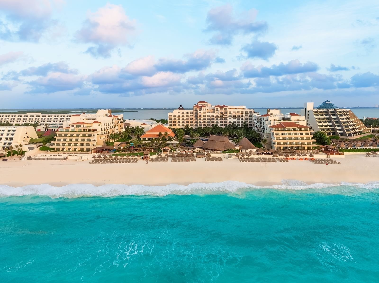 Vista aérea del resort Fiesta Americana Condesa Cancún, frente a una amplia playa de arena blanca y el mar turquesa